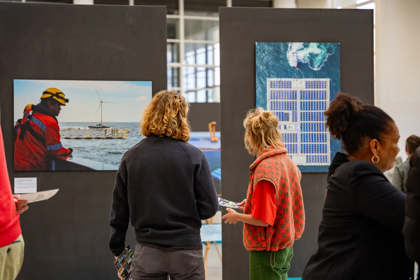 Visitors looking at the photographs during the opening of Beyond the Surface